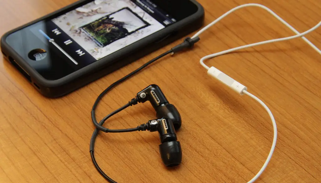 Wired over-ear headphones connected to a portable DAC and amplifier for hi-res playback
