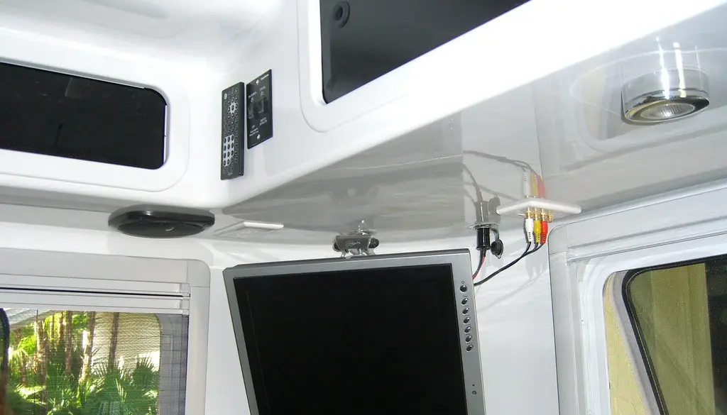 A television mounted on a wall with a soft bias light glow behind it
