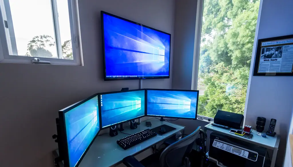 A large 4K TV mounted on a wall in a dimly lit living room