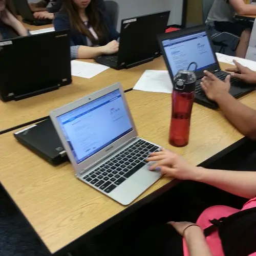 A Chromebook laptop open on a desk with the Linux terminal visible