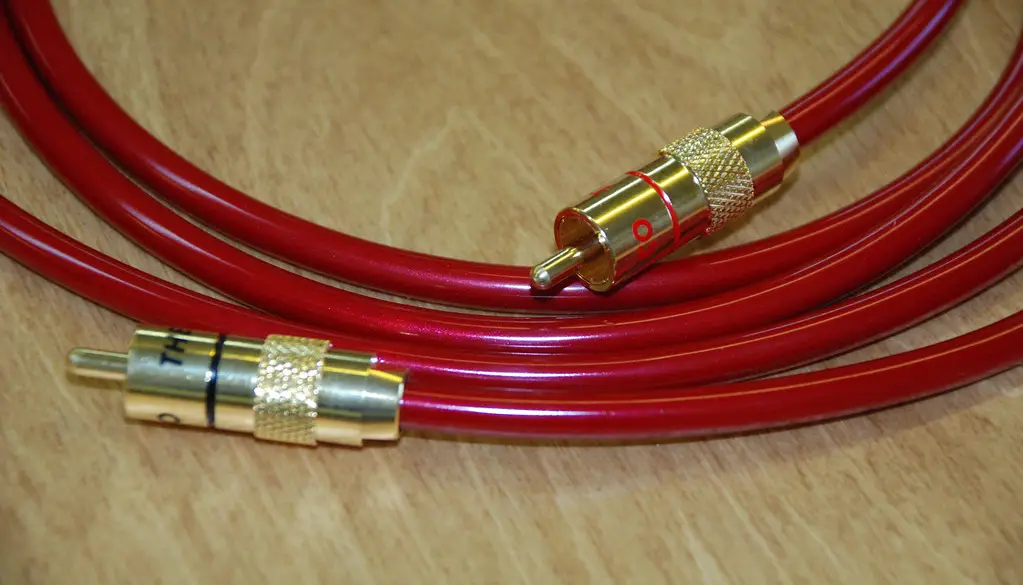Wired headphones connected to a smartphone playing music in a streaming app