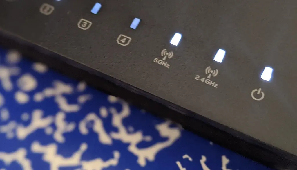 A home Wi-Fi router with indicator lights on a shelf