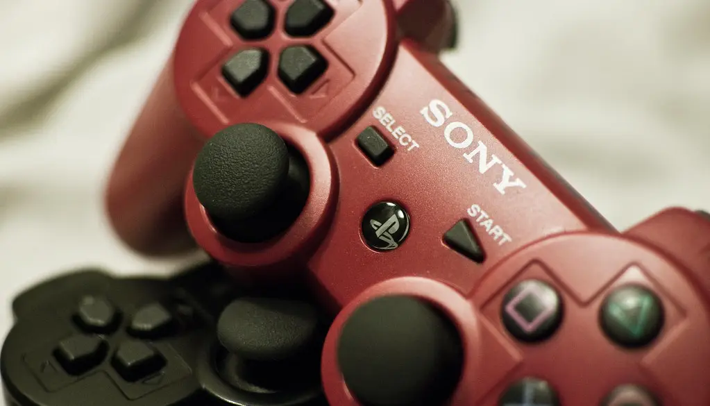 A game controller held in front of a large television running a game
