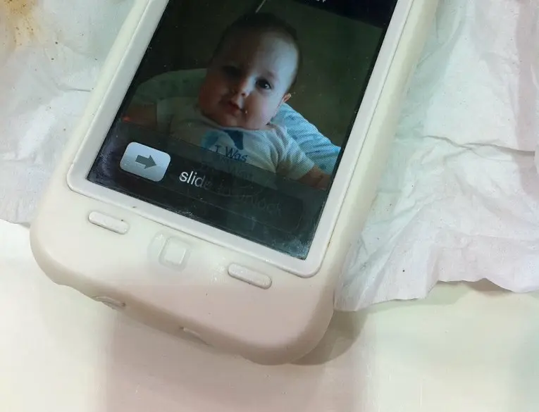 A hand holding an iPhone displaying the Battery settings screen