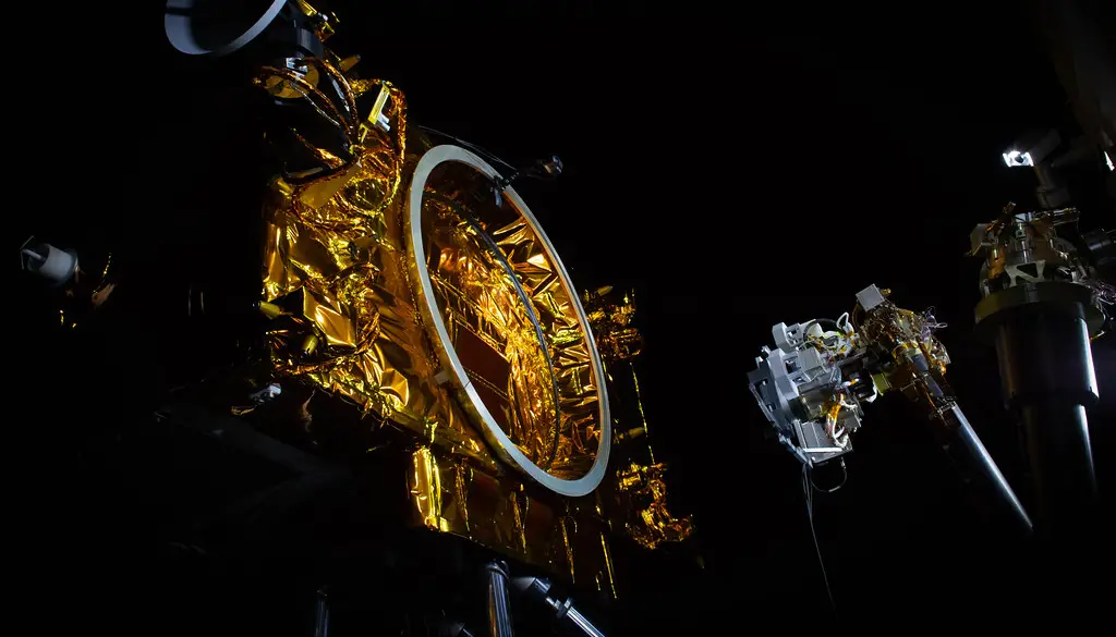 A robotic servicing spacecraft approaching a satellite in orbit