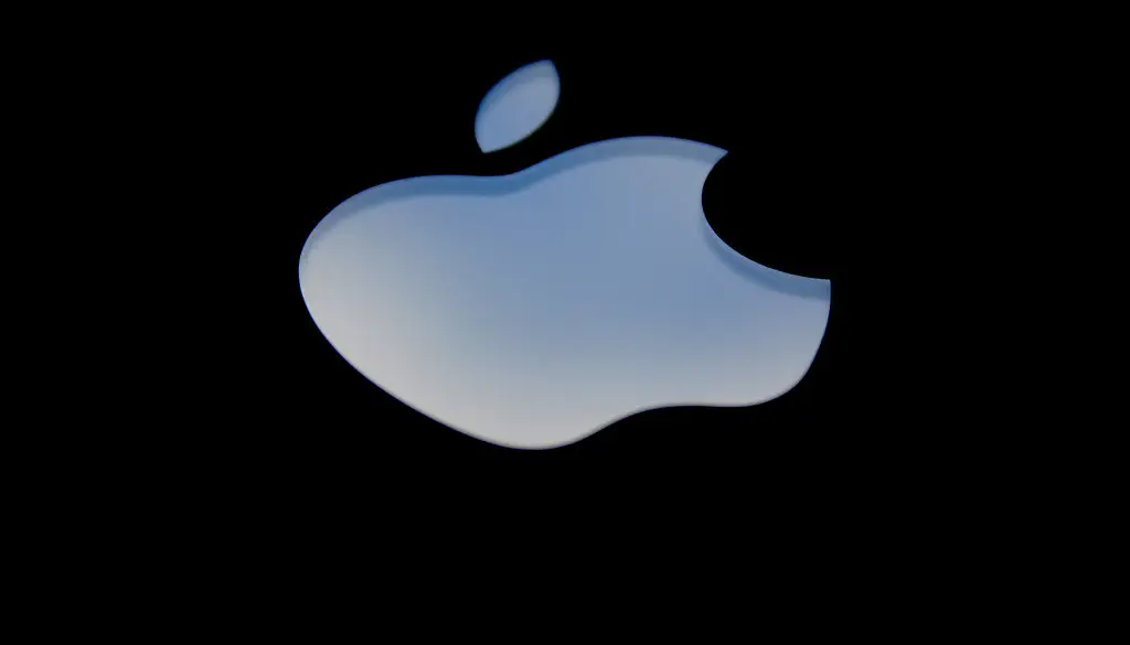 A MacBook displaying a colorful desktop with translucent interface elements