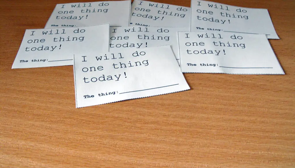 A stack of paper documents on a desk being split into smaller annotated sections