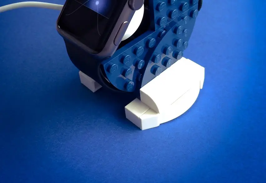 An Apple Watch charging on a bedside table at night