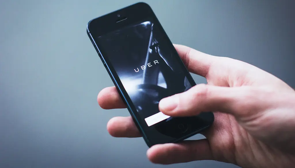 A hand holding a smartphone showing a secure login and password manager screen